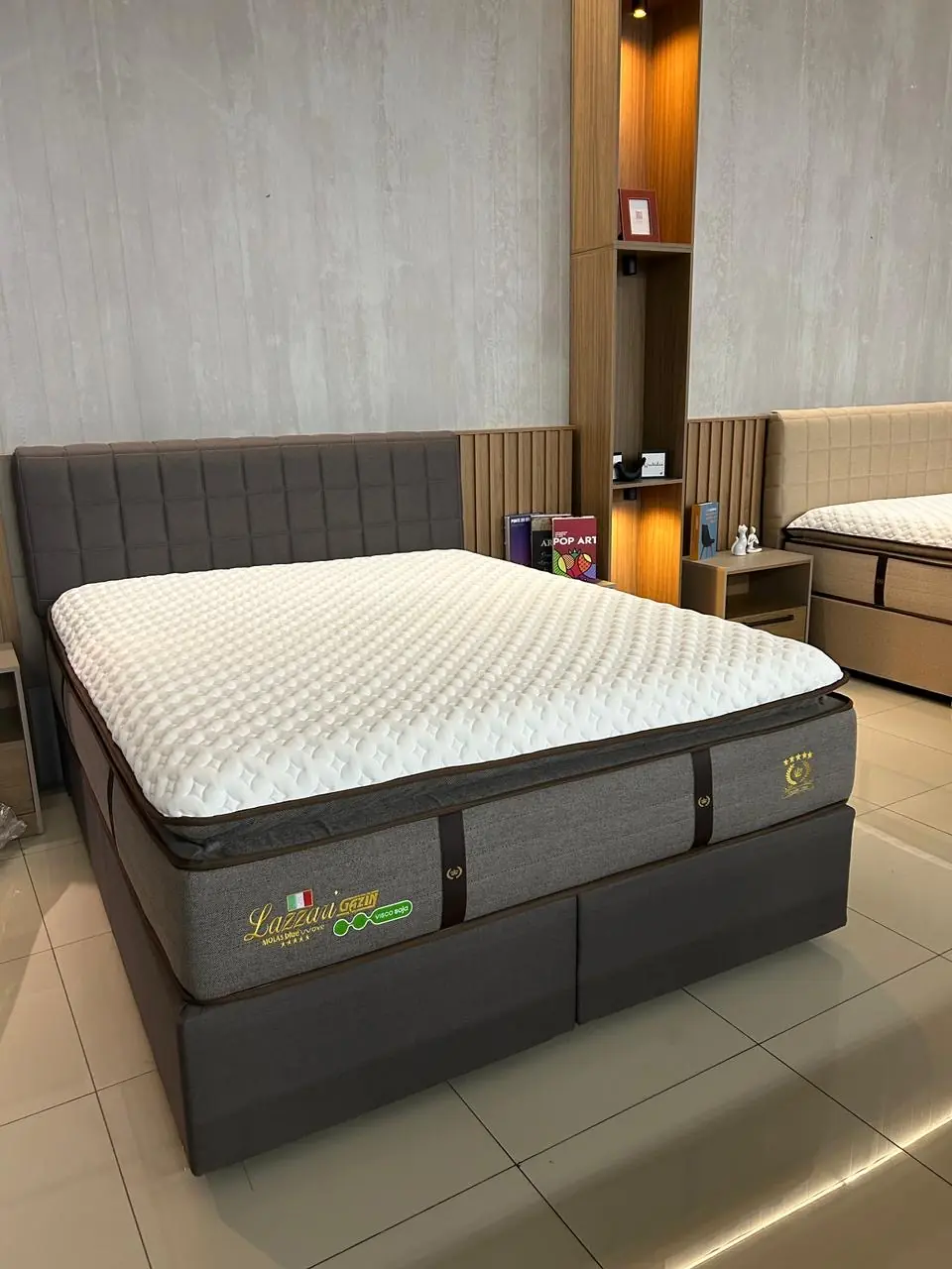 Conjunto de colchão Gazin com cabeceira cinza no showroom