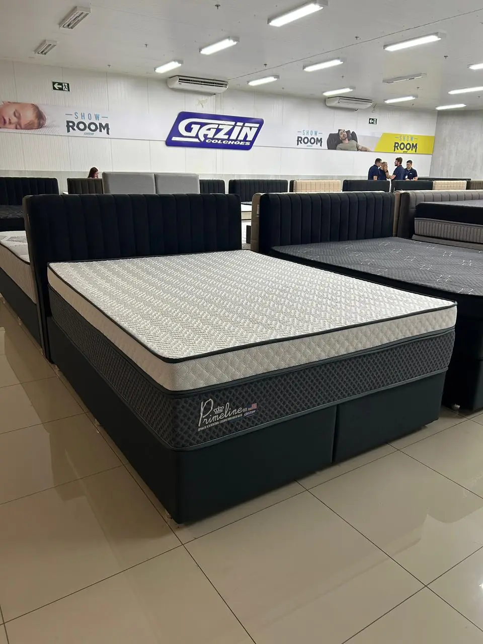 Colchão Prime Line com base e cabeceira escura no showroom Gazin